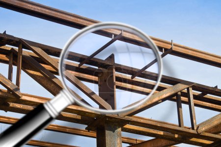 Photo for Old rusty iron structure with bolted metal profiles against a blue sky - Concept image seen through a magnifying glass - Royalty Free Image