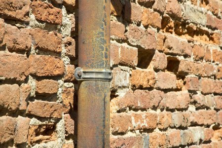 Foto de Vieja tubería de cobre oxidado y hierro fundido contra una pared de ladrillo - Imagen libre de derechos