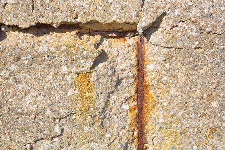 Alte Stahlbetonwand ohne Betonabdeckung durch Oxidation mit beschädigter und rostiger metallischer Bewehrung