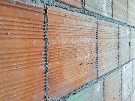 Foto de Muro de ladrillo hecho con ladrillos huecos utilizados para hacer particiones de luz dentro de los edificios en un sitio de construcción italiano - Imagen libre de derechos