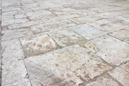 Old white limestone paving made with stone blocks of rectangular shape in a pedestrian zon