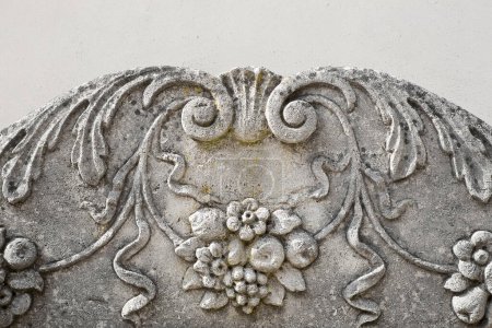 Detalle de la decoración floral de una fachada italiana con decoración de piedra y estuco
