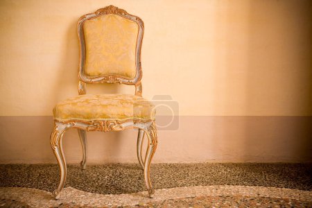 Alter italienischer Holzgepolsterter Stuhl, gerade mit floralen Dekorationen restauriert - Bild mit Kopierraum
