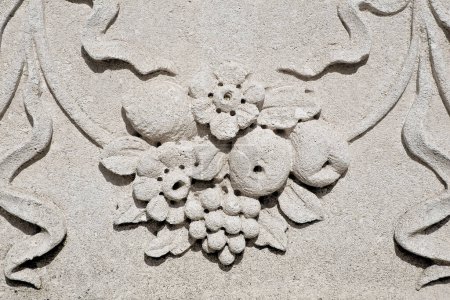 Detalle de la decoración floral de una fachada italiana con decoración de piedra y estuco