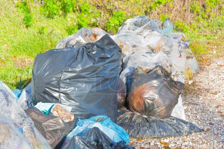 Illegal dumping with plastic bags abandoned in nature