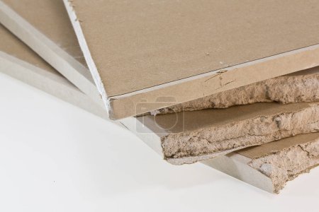 Zerbrochene Stücke von Gipskartonplatten, die in der Bautätigkeit und Bauindustrie verwendet werden - Trockenbau-Materialkonzept - Sie können das Innere des Materials sehen