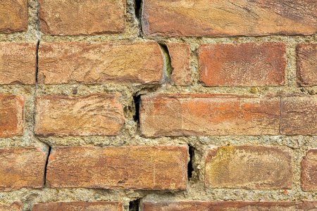 vieux mur de briques fissurées exposé dangereux en raison de la rupture de fondation structurelle, affaissement du sol, tremblement de terre, corrosion et détérioration des matériaux de construction,