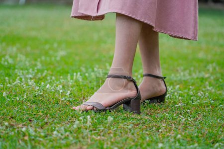 Photo for Close up of woman feet in summer. sandals shoes. high heels. with fresh green grass. - Royalty Free Image