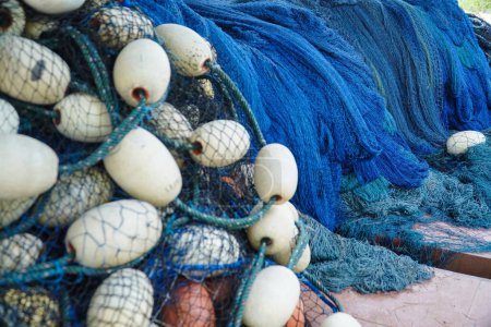 Foto de Pila de red de pesca azul con flotadores blancos. Red de pesca de arrastre y flotadores. Redes de pesca y cuerdas. herramienta para la captura de peces - Imagen libre de derechos