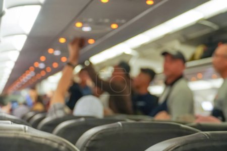 Téléchargez les photos : Fond flou de l'avion intérieur, cabine de bagages. l'atmosphère dans la cabine de l'aéronef avant le vol - en image libre de droit