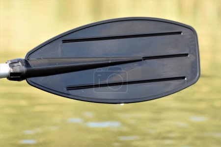 Photo for Black oar on water river background close up - Royalty Free Image
