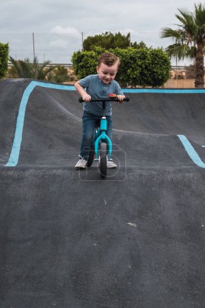 Photo for A young child rides the new South Glenmore Park BMX pump track on his bike on a summer evening in Calgary Alberta Canada. - Royalty Free Image
