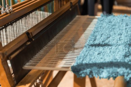 Foto de Maestro tejedor está tejiendo el tapiz con diversos hilos brillantes, de cerca. Artesanal en el trabajo. - Imagen libre de derechos