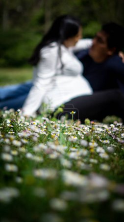 Foto de Joven pareja en el amor sentado en la hierba - Imagen libre de derechos