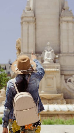 Foto de Joven turista delante de una estatua en una plaza en una tarde de verano - Imagen libre de derechos