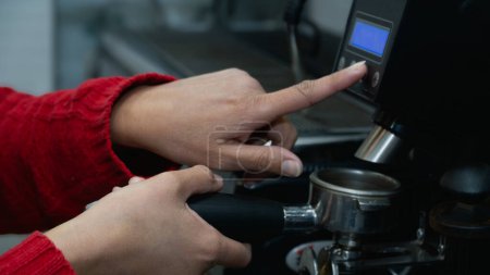 Foto de Barista mano montaje de la amoladora para iniciar la molienda de café y la preparación de un espresso. - Imagen libre de derechos