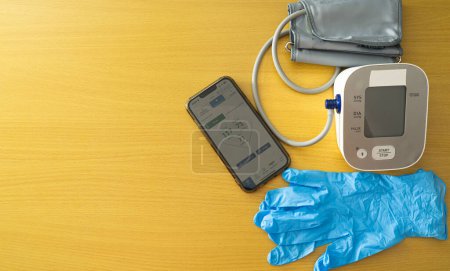 Foto de Un teléfono inteligente y un monitor de presión arterial están en una mesa - Imagen libre de derechos