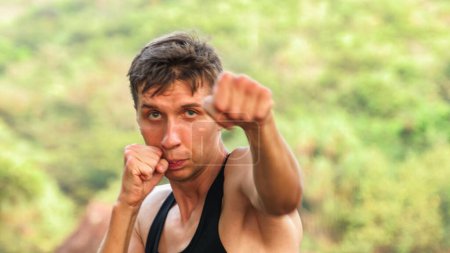 Photo for Young man throwing a left-handed punch directly at the camera. High quality photo - Royalty Free Image
