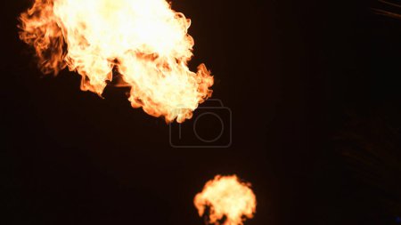 Téléchargez les photos : Flashs de feu sur un fond noir lors d'un spectacle de feu. Photo de haute qualité - en image libre de droit