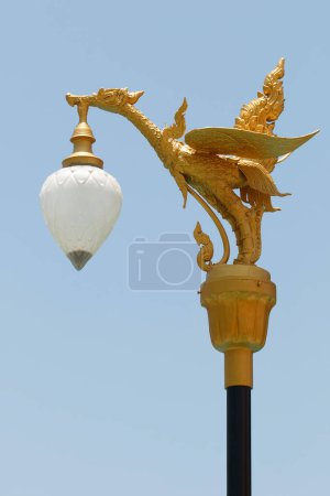 It is Hanging lamp with black pole and sky background.