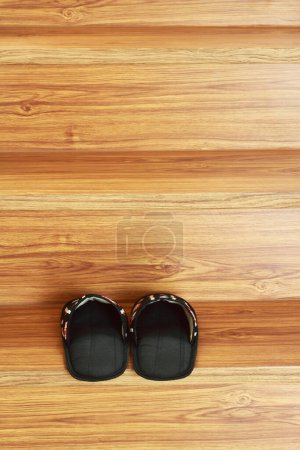it is preparing black slipper on wooden stairs.