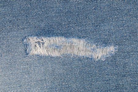 it is tear on blue jeans for pattern and background.