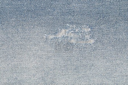 it is tear on blue jeans for pattern and background.