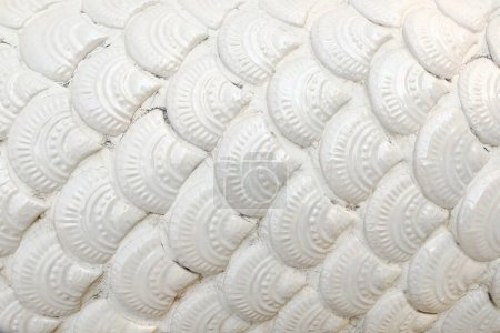 it is white ceramic tiled naga scale for pattern and background.