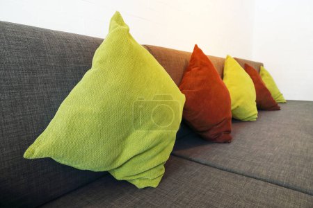 it is colorful pillows on long sofa for pattern and background.