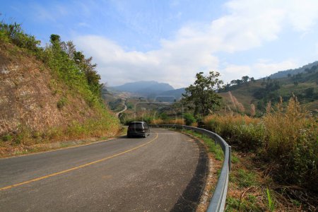 Téléchargez les photos : Black car on asphalt road go down and up to hill along with mountains and clouds blue sky background at Phu Lanka Forest Park, Phayao, Thailand. Beauty of natural. Beautiful pathway, Travel and street - en image libre de droit