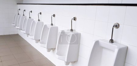 Photo for White urinal on white wall in men public toilet, washroom or rest room. Object, Interior design, Sanitary ware and Sanitation concept - Royalty Free Image