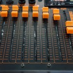 Close up orange button of sound mixer panel equipment for mixing or control audio system with selective focus technique. Technology, Tool and Digital device concept. 