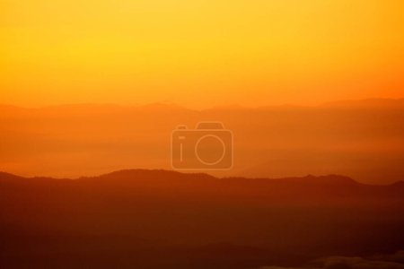 Beautiful orange sunlight or sunrise in morning with silhouette of big mountain for background at Doi Chiang Dao, Doi Luang Chiang Dao, Chiangmai, Thailand. Landmark and Beauty of Nature concep