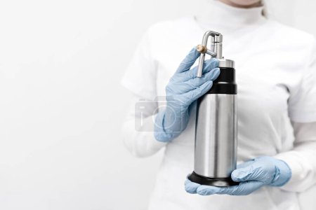 Photo for Cryotherapy or cryosurgery - cold treatment. liquid nitrogen in a special device with a probe - cryodestructors. the doctor the dermatologist doing the procedure - cryotherapy - cold treatment is a special apparatus with cryodestruction - Royalty Free Image
