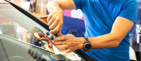Photo for Specialist fixing crack on car windshield in repair shop. High quality photo - Royalty Free Image