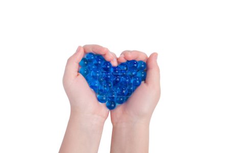 Corazón hecho de orbisas azules. Orbises azules en mano aislados en blanco. 
