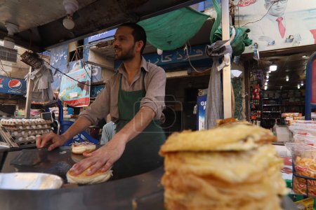 Téléchargez les photos : Burns Road mars 2021, Un jeune homme faisant Bun Kebab à la célèbre et vieille rue de la nourriture de Karachi, restaurants de Karachi. - en image libre de droit