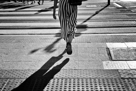 Photo for Woman legs walking downtown on the crosswalk in a European city - Royalty Free Image