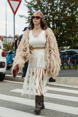 Photo for A guest white top and skirt, beige shaggy knitted coat, black boots, seen outside PRADA show during Milan Fashion Week Womenswear Spring/Summer 2024. - Royalty Free Image