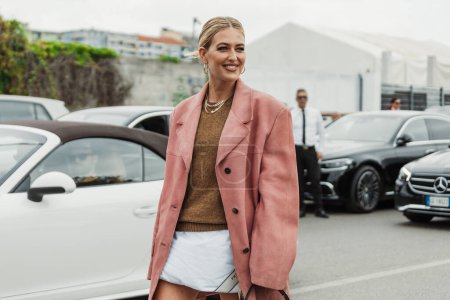 Foto de Emili Sindlev lleva collares, un jersey de punto, una chaqueta de gamuza rosa de gran tamaño, bolso Prada, visto fuera del programa PRADA durante Milan Fashion Week Womenswear Primavera / Verano 2024. - Imagen libre de derechos