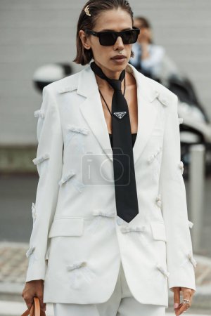 Téléchargez les photos : Un invité porte un pantalon blanc, une cravate Prada noire, des sandales plates-formes noires et un sac vu à l'extérieur du défilé PRADA pendant la Fashion Week de Milan Vêtements Femme Printemps / Été 2024. - en image libre de droit