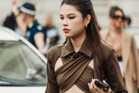 Foto de Una invitada lleva una blusa marrón cruzada en el pecho, vista fuera del espectáculo MAX MARA durante la Semana de la Moda de Milán Ropa Mujer Primavera / Verano 2024. - Imagen libre de derechos