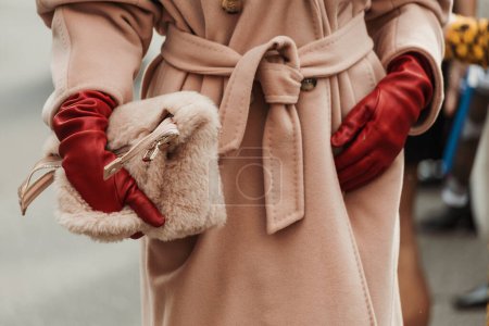 Foto de Detalles de moda. Anna Rosa Vitiello lleva gafas de sol rojas, guantes de cuero rojo, una gabardina de lana rosa, vista fuera del espectáculo MAX MARA durante la Semana de la Moda de Milán Ropa de mujer Primavera / Verano 2024. - Imagen libre de derechos