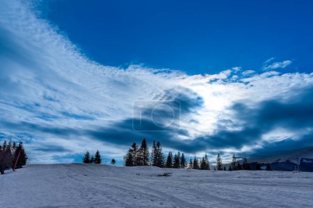Photo for Sun over snowy Nord-East slopes of Polonina Borzhava from Izky village, Carpathian mountains, Ukraine - Royalty Free Image