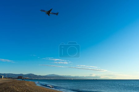 Photo for MALAGA, SPAIN - JANUARY 21, 2023: Airplane landing at sunrise over Mediterranean Sea, Costa del Sol in Malaga, Spain on January 21, 2023 - Royalty Free Image