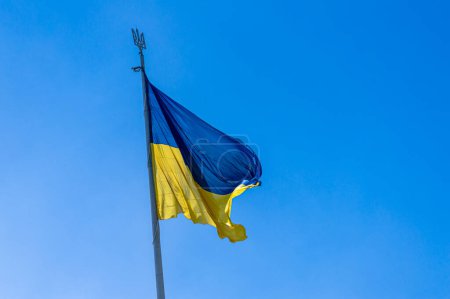 Le drapeau national de l'Ukraine flotte sur le vent dans le ciel bleu