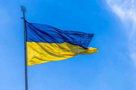 Foto de La bandera nacional de Ucrania ondea en el viento en el cielo azul - Imagen libre de derechos