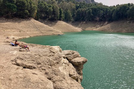 Foto de EL CHORRO, ESPAÑA - 19 DE MARZO DE 2024: Descanso en el lago Embalse conde de Guadalhorce el día soleado en El Chorro, Málaga, España el 19 de marzo de 2024 - Imagen libre de derechos