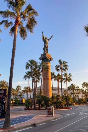 Téléchargez les photos : BANUS, ESPAGNE - 16 MARS 2024 : Statue La Victoria au lever du soleil à Banus, Espagne le 16 mars 2024 - en image libre de droit