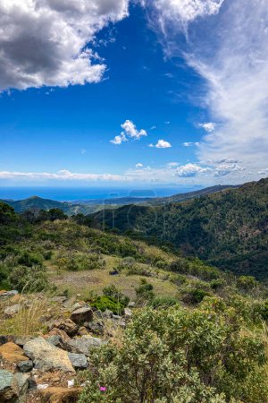 Wolken am blauen Himmel über Bergen und Meer im Nationalpark Sierra de las Nieves, Andalusien, Südspanien